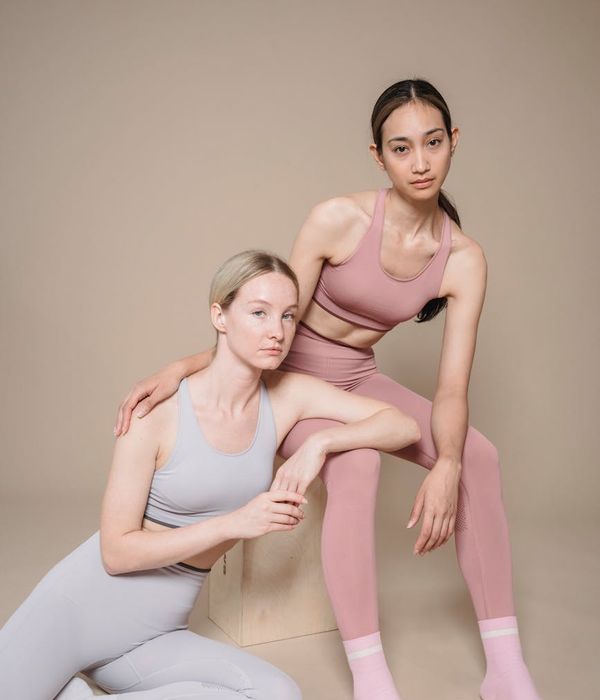 Woman in a graceful yoga pose with pink and charcoal color accents.